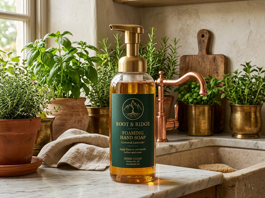 Root & Ridge natural foaming hand soap in an amber pump bottle on a marble kitchen counter with potted herbs